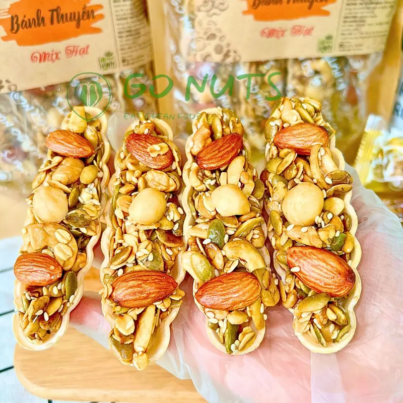 Biscoito crocante GO NUTS em formato de barquinho, com mix de castanhas, macadâmia e cereais, sem açúcar, adoçado com mel